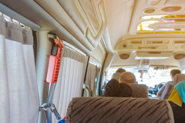 Montaje de martillo de vidrio de seguridad naranja cerca del vidrio de la ventana y la cortina en la furgoneta para usar para romper el vidrio en caso de accidente
. - Foto, imagen