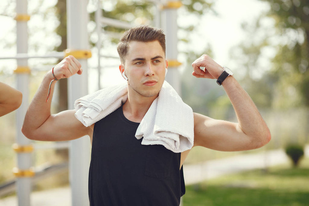 Handsome man training in a summer park - Photo, Image
