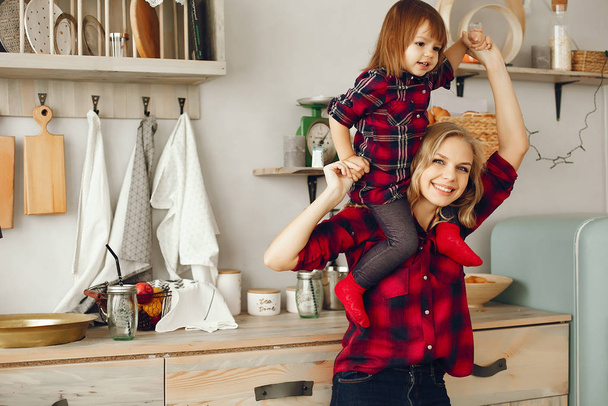 Mother with little daughter in a kitchen - Foto, imagen