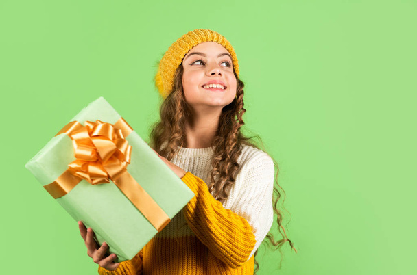 Kid hold present box. Shopping mall concept. Birthday celebration idea. Good mood. Birthday tradition. Happy winter holidays. Cheerful little girl knitted hat and sweater. Birthday surprise - Valokuva, kuva