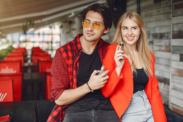 Stylish young couple with vape in a city - Foto, imagen