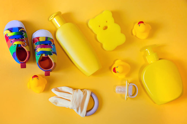 Akcesoria do kąpieli noworodków na żółtym tle. Skupienie selektywne. - Zdjęcie, obraz