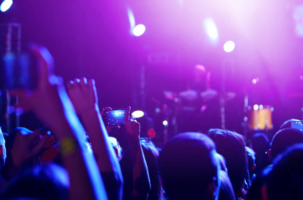 Рука с телефонными записями фестиваля живой музыки. Люди фотографируют со смартфона во время концерта публичной музыки. Толпа поднимает руки, танцует и наслаждается большим концертом
. - Фото, изображение