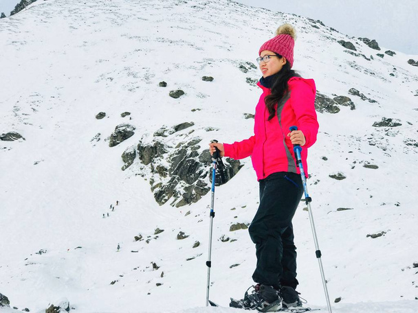 молода жінка пішки в засніжених горах
 - Фото, зображення
