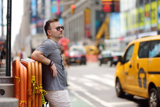 Турист средних лет, смотрящий на Таймс-сквер в солнечный летний день, Манхэттен, Нью-Йорк
. - Фото, изображение