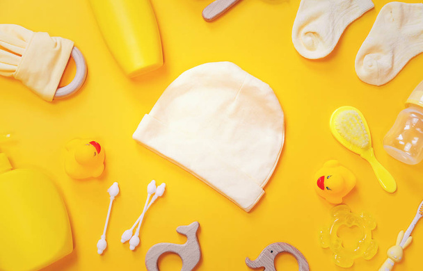 Accesorios para recién nacidos sobre fondo amarillo. Enfoque selectivo
. - Foto, imagen