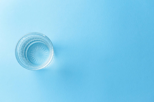 Склянка чистої води на кольоровому фоні
 - Фото, зображення