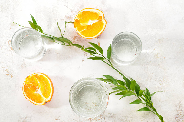Glasses of clean water and orange on light background - Фото, зображення