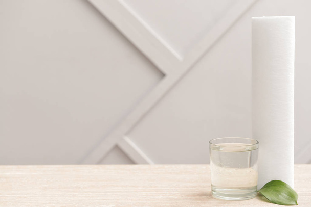 Склянка чистої води і фільтр на столі
 - Фото, зображення