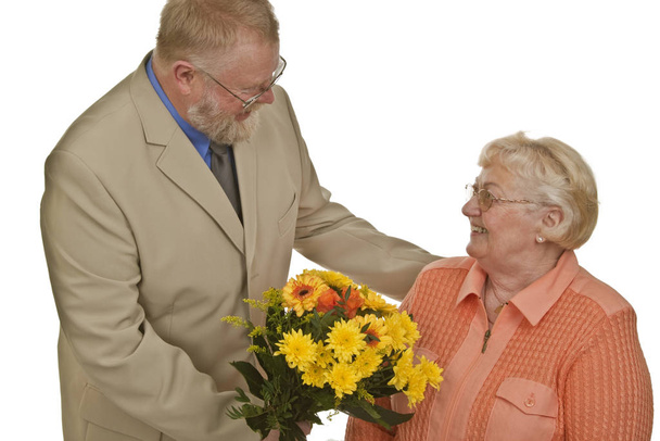 happy senior couple with flowers isolated on white - Foto, afbeelding