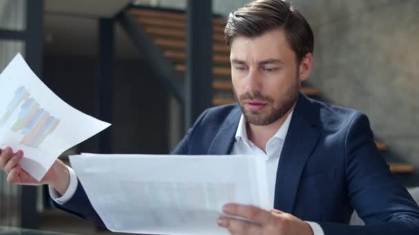 Serious businessman looking on diagram in office. Focused man reading documents. - Video, Çekim