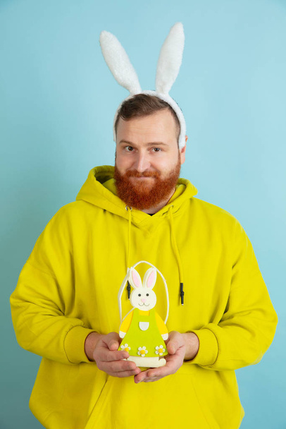 Easter bunny man with bright emotions on blue studio background - Photo, Image