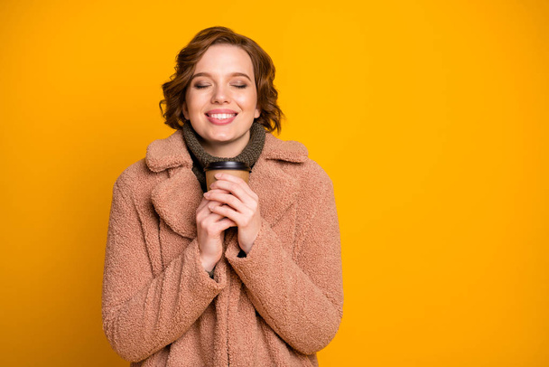 Close-up portrait of her she nice attractive lovely pretty charming cute dreamy cheerful cheery girl drinking hot beverage wintertime isolated over bright vivid shine vibrant yellow color background - Fotoğraf, Görsel
