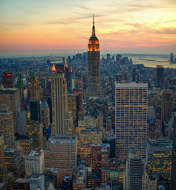 A high angle shot of city buildings in new york manhattan with a sunrise in the background - Photo, Image