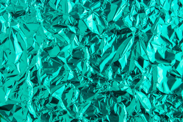 abstrakte trendige grün gefärbte zerknüllte Folie Textur Hintergrund. 2020 Jahr Farbtrend Konzept. - Foto, Bild
