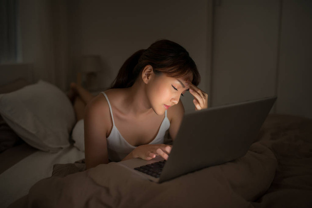 Schlafzimmerabend - Frau mit Laptop im Bett liegend - Foto, Bild