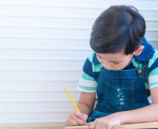 Asyalı çocuk çocuk çocuk eğitimi için odunları dikmek için kalem kullanıyor. - Fotoğraf, Görsel