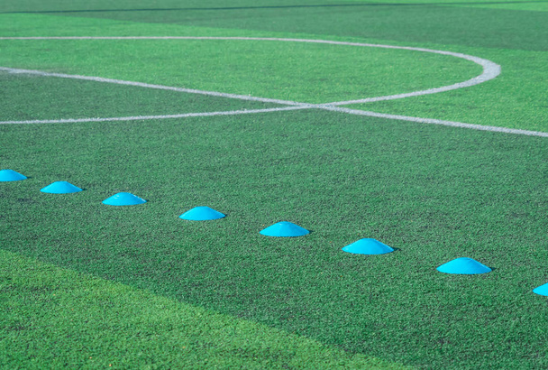 Голубой спорт Маркер на зеленой травяной футбольной площадке
 - Фото, изображение