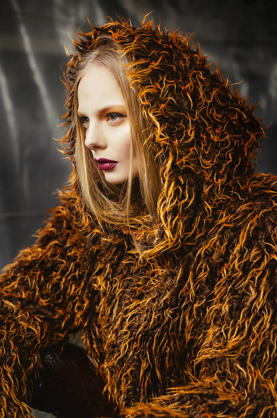 young beautiful  woman in faux fur coat posing on street - Fotografie, Obrázek