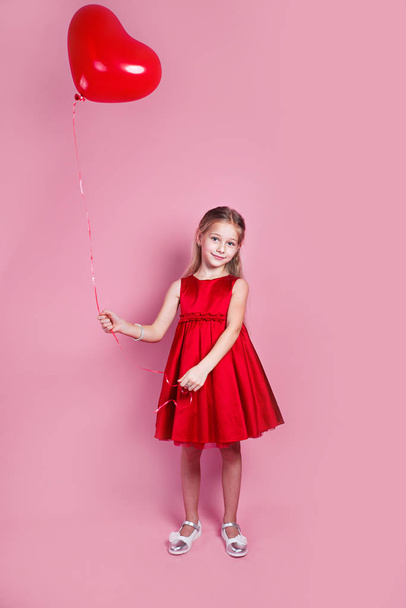 Little girl in red dress with heart shape air balloon - Zdjęcie, obraz