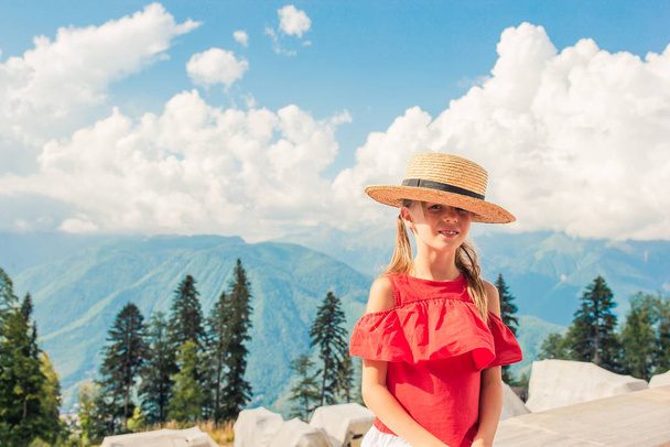 mooi gelukkig klein meisje in bergen in de achtergrond van mist - Foto, afbeelding
