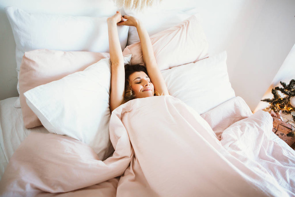 mujer estirándose en la cama después de despertar - Foto, imagen