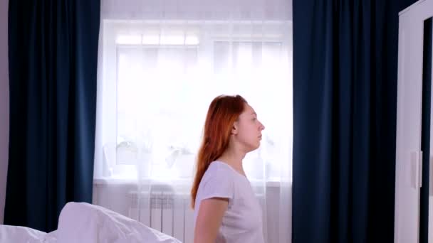 Redhead woman Stretches and Gets Up from the Bed. - Imágenes, Vídeo