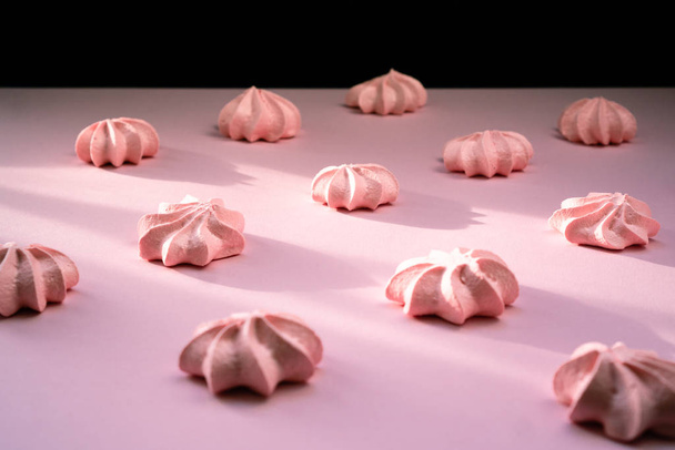 Pink meringue with rows on the same background - Foto, Bild