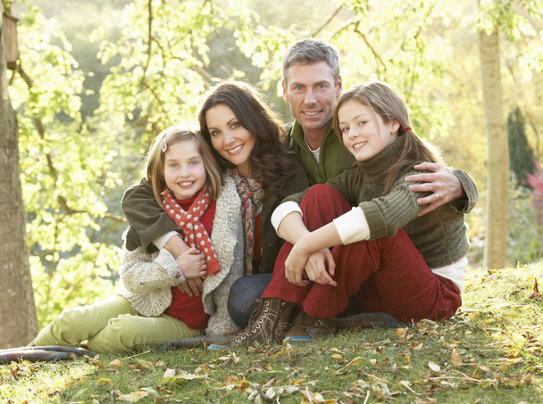 Family Group Relaxing Outdoors In Autumn Landscape - Foto, afbeelding