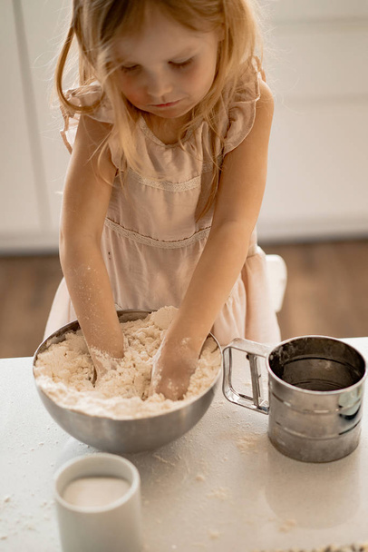 girl helps mom in the kitchen to cook Easter cakes.  Happy family preparing for Easter - Photo, image