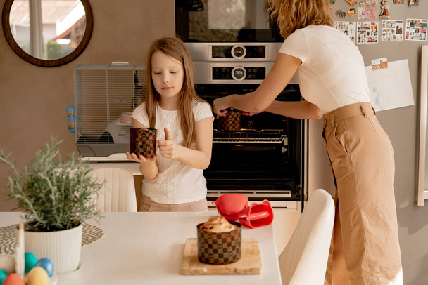 young woman with daughter prepares Easter cake with dried fruits and raisins - Foto, Imagen