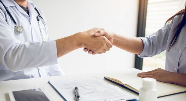 Doctor shaking hands with older patient in the clinic room. - Photo, image