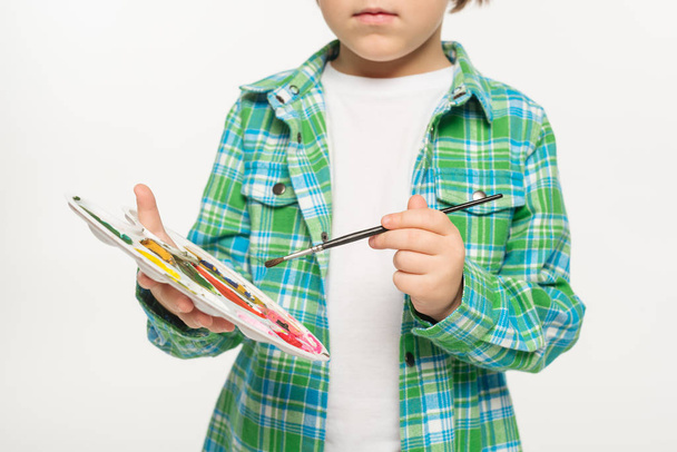  cropped view of boy in checkered shirt holding palette and paintbrush isolated on white - Photo, image