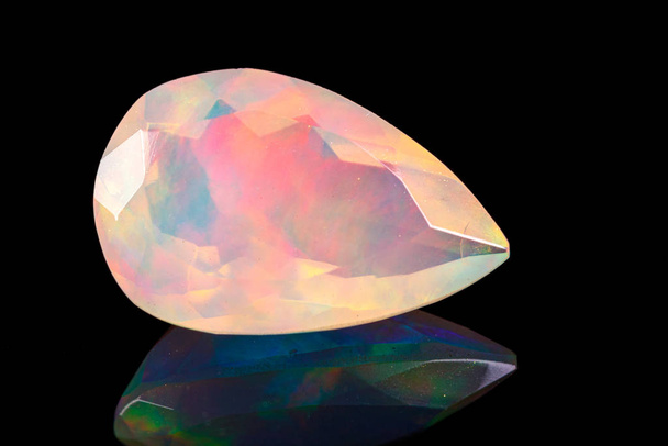 Makro-Mineralstein facettiert Opal auf schwarzem Hintergrund  - Foto, Bild