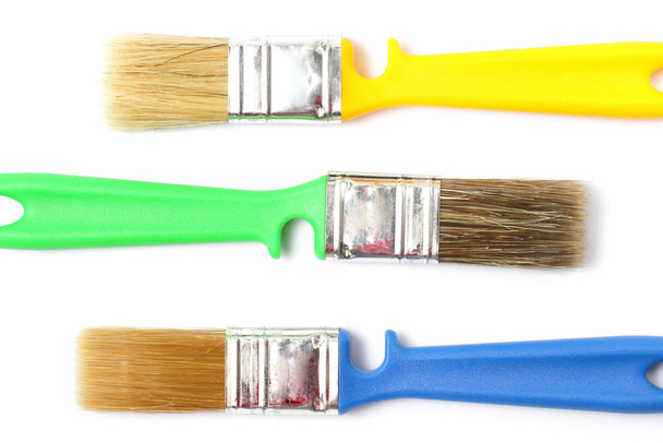 Colored paint brushes with plastic handles on a white background, isolate, flat layer, close-up. - Foto, immagini