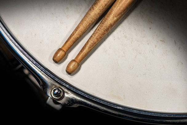 Две деревянные барабанные палочки на старом барабане - ударный инструмент
 - Фото, изображение