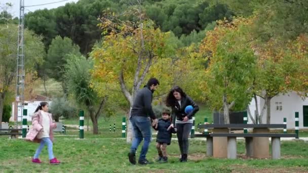 happy family in park run forward into camera - Felvétel, videó
