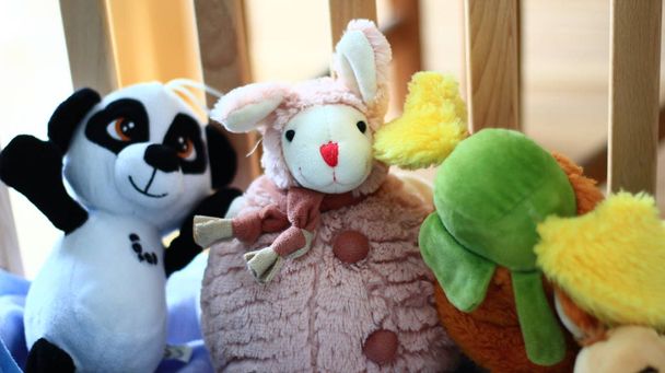 Vivid plush toys in a baby cot. - Photo, Image