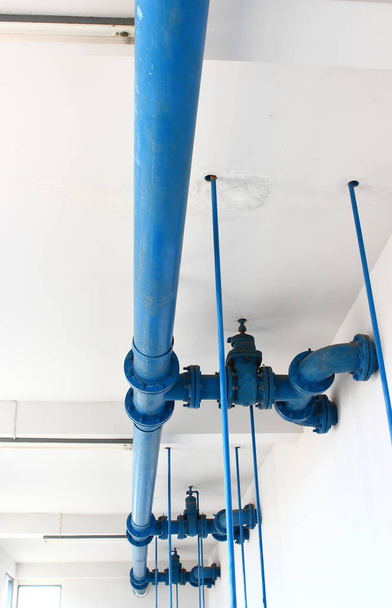 línea de tubería azul con válvula azul en la pared
 - Foto, imagen