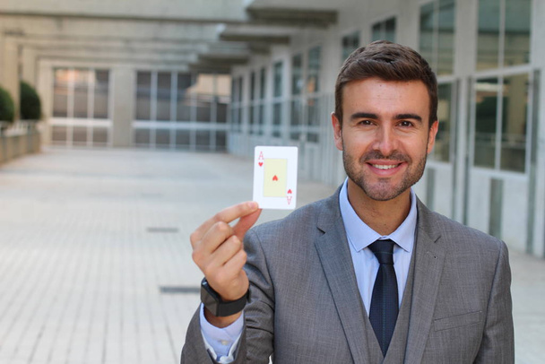 primer plano retrato de guapo joven empresario sosteniendo as de corazones tarjeta en la calle
 - Foto, Imagen
