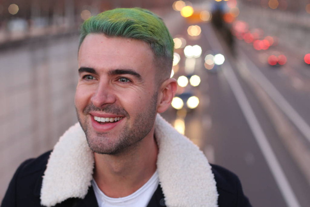 Trendsetter with green hair smiling, blurred city background  - Photo, Image