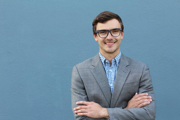 close-up retrato de belo jovem empresário em terno cinza na frente da parede azul
 - Foto, Imagem