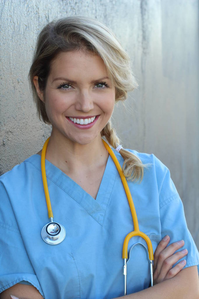 Profissionais médicos: enfermeira sorrindo enquanto trabalhava no hospital. Jovem linda loira caucasiana mulher assistente de saúde
 - Foto, Imagem