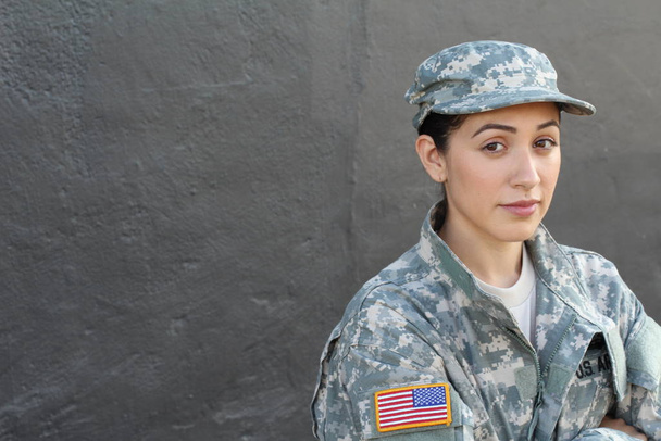 Muotokuva kaunis nuori tyttö yllään vihreä sotilaallinen tyyli takki ja hattu, harmaa seinä tausta
  - Valokuva, kuva