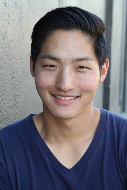 Nahaufnahme Porträt eines hübschen jungen asiatischen Mannes im blauen Hemd - Foto, Bild