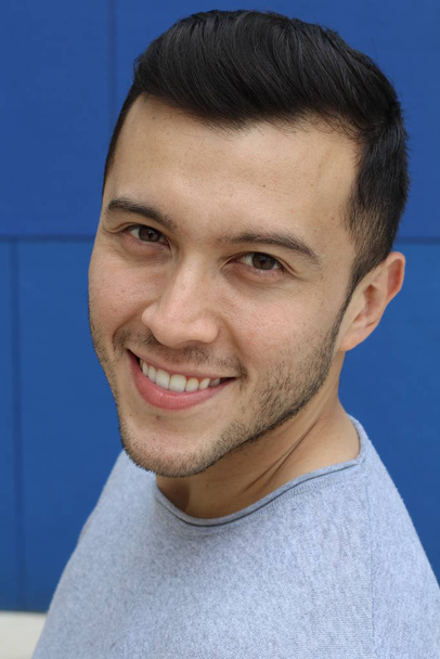 Χαριτωμένο εθνοτικός άνθρωπος χαμογελά σε μπλε φόντο με αντίγραφο χώρο - Φωτογραφία, εικόνα