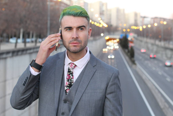 優雅なハンサムな男とともに緑の髪の話電話で街 - 写真・画像