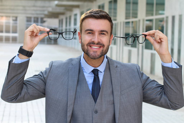 close-up portrait of handsome young businessman with eyeglasses showing excited expression on street - Фото, зображення