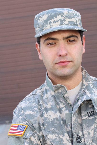 közelkép portré jóképű fiatal katona barna fal háttér - Fotó, kép