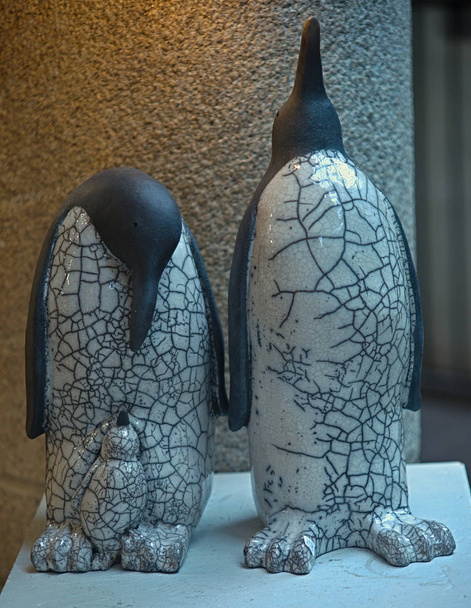 Керамические фигурки пингвинов на деревянной полке
 - Фото, изображение